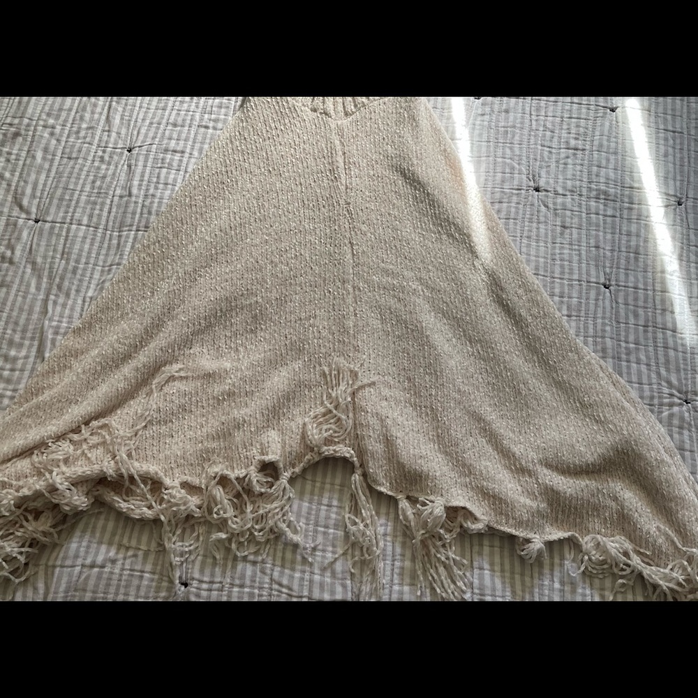 Pinklicious knitted poncho. Used in a crème color